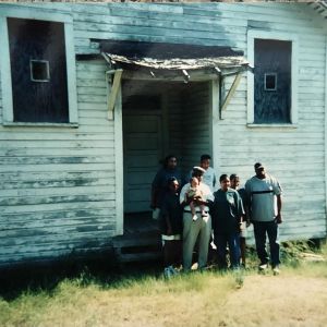 family in front of dilapidated house
