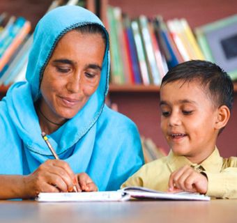 A woman writing in a notebook with a boy