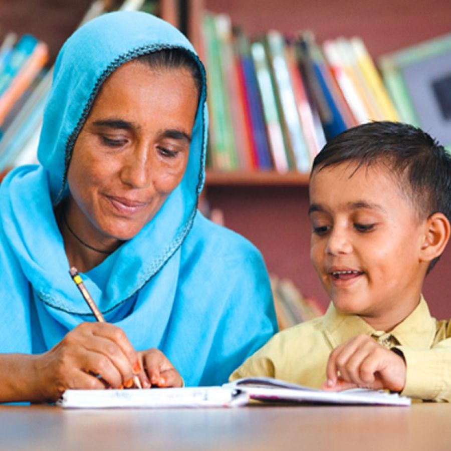 A woman writing in a notebook with a boy