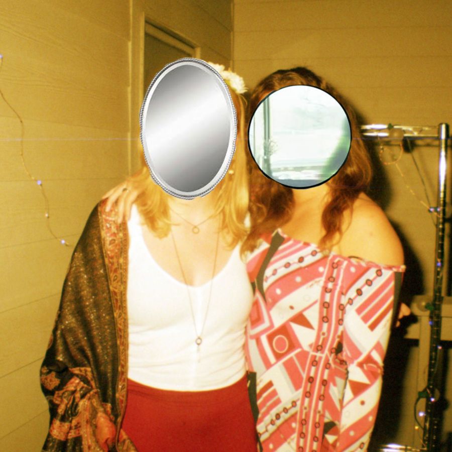 A photo of two women with mirrors where their faces should be.