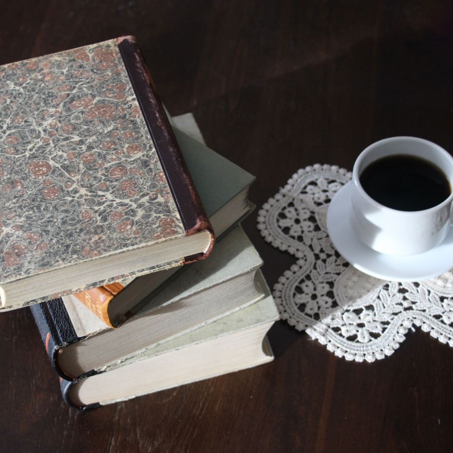 Cup of coffee next to a stack of books